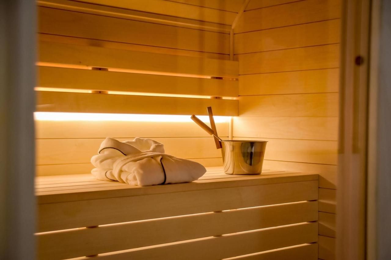 Sauna z podświetlonymi ławami, szlafrokiem i drewnianym cebrzykiem