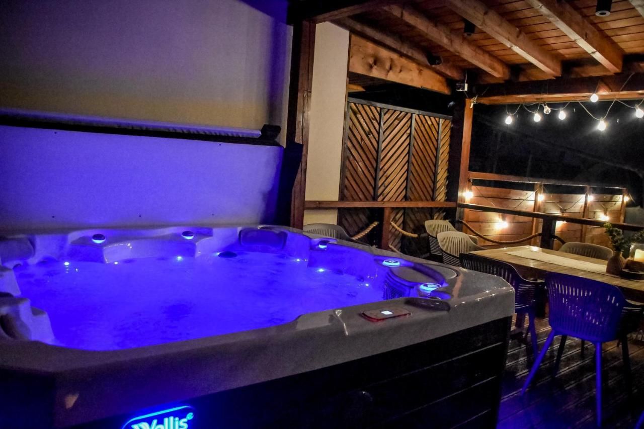 Podświetlone na niebiesko jacuzzi na tarasie wieczorem